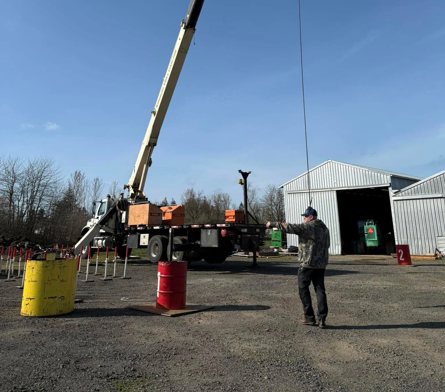 Image of a large crane and a man directing the lift | Crane Safe LLC